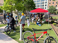 A red bike sitting on the grass with people in the background