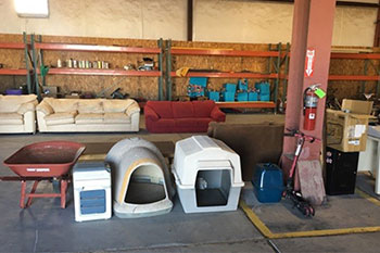 Items at the country store stuch as dog houses, wheel barrels.